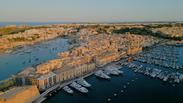 Aerial 4K 180-degree panorama of Senglea city and cruise ships in the Grand Harbour at sunset, Malta

