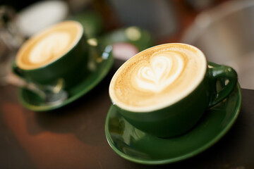 Cup, coffee and caffeine on table at cafe for morning beverage, brewing and cappuccino liquid. Latte, design art and espresso drink for customer service, aesthetic presentation and bistro hospitality