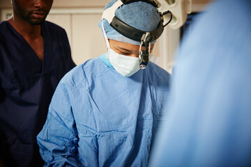 Medical, headlight or doctor in hospital for surgery, observation or precision in emergency service. Healthcare, team or people in clinic with equipment, inspection or attention in client operation.