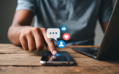 Person using smartphone with social media icons and laptop in background mobile phone technology
