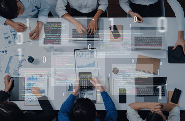 Business team collaborates in a modern office environment, analyzing data and discussing coding strategies using laptops, notebooks, and digital tools. Trope