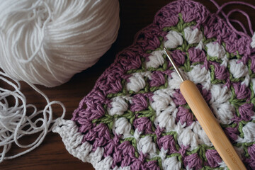 Unfinished square napkin, Crochet hook and ball of white yarn