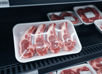 Fresh lamb chop meat package in a store cooler. Red meat in vacuum sealed tray for grocery store sales. Food and cooking ingredient concept.