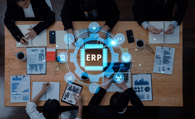 A diverse team of professionals collaborates in a modern office, discussing ERP strategies while analyzing financial data and using digital tools for effective management. Trope