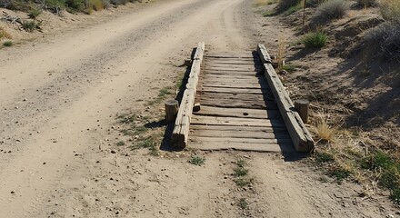 Rustic Wooden Bridge Crossing a Dirt Road in the Countryside.