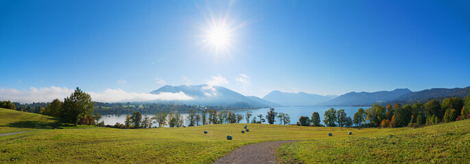 morning scenery Gmund am Tegernsee, pasture with haybales, lake and alps view