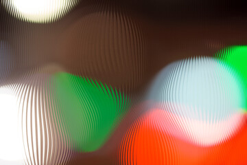 Abstract colorful traffic lights distortion through ribbed glass. Green, red and white bokeh texture.