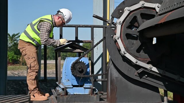 Industrial Worker Performing Equipment Inspection with Safety Gear