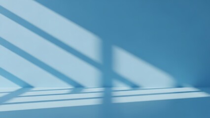 Minimalist light blue room corner with diagonal window shadows casting soft patterns on the wall and floor surface, empty studio backdrop