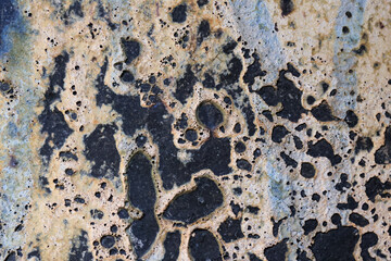 Abstract macro background showing gritty detail of weathered, corroded, and rough metal surface. This grunge texture with pitted pattern has distinct aged feel