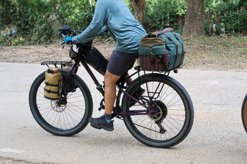 Obraz premium Cyclist on bikepacking adventure tour, riding bicycle with luggage and gear. Person enjoying freedom of an outdoor travel journey on an active holiday expedition