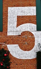 Fototapeta premium The number 5 painted on the brick wall of a building 