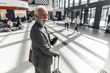 Senior Businessman Traveling in Modern Building Interior with Sunlit Hallway