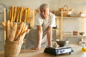 Humorous portrait of fan male baker with a sieve on his head