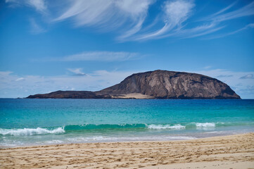 Fototapeta premium Playa de las Conchas, La Graciosa. Golden sand beach and turquoise blue ocean in a pristine natural reserve under the warm sun in Canary Islands.