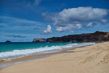 Playa de las Conchas, La Graciosa. Golden sand beach and turquoise blue ocean in a pristine natural reserve under the warm sun in Canary Islands.