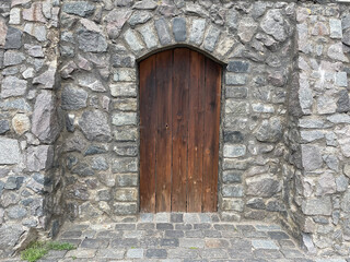 An old brown wooden door in a wall