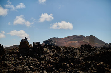 Dramatic volcanic landscape and red earth of Timanfaya National Park, an otherworldly scenic tourist attraction, Lanzarote, Spain