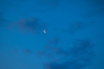 A beautiful moon shining in the night sky over Latvia, Europe. A summer scenery at nighttime.