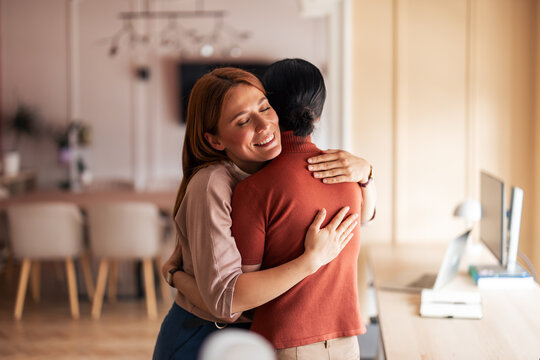 Two Individuals Sharing an Emotional Hug in a Cozy Office Setting