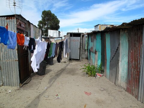 Laundry hangs between corrugated shacks in Khayelitsha, showing everyday life and vibrant township culture in South Africa.