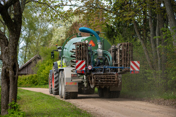 Farm vehicle disappearing into spring forest