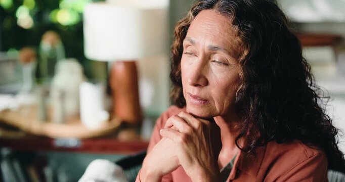 Thinking, depression and mature woman in home with loneliness, stress or remember past with regret. Reflection, sad and person in living room with anxiety for mental health, nostalgia and flashback
