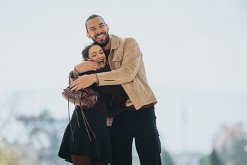Two friends share a joyful hug in a sunny park, radiating warmth and connection. Casual outfits and bright setting convey happiness, friendship, and carefree moments outdoors.