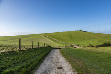 Looking along a chalk pathway leading to Truleigh Hill in the South Downs, with a blue sky overhead