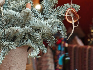 Close-up Christmas tree branches with ornaments in cozy restaurant interior.