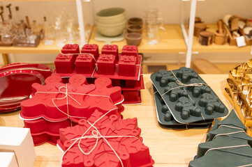 Colorful silicone baking molds displayed on wooden shelves in a store