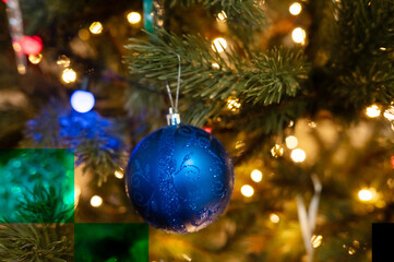 Blue ornament on christmas tree with lights and pine branches