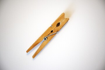 Single wood- material clothespin isolated on a white background in natural condition. Minimal and simple household object.