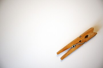 Single wood- material clothespin isolated on a white background in natural condition. Minimal and simple household object.