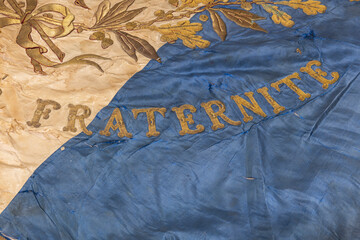 D&eacute;tail d'un vieux drapeau fran&ccedil;ais sur lequel est &eacute;crit le mot " Fraternit&eacute; "