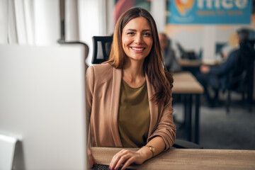 Confident Professional Woman in Modern Office Environment Smiling at Camera