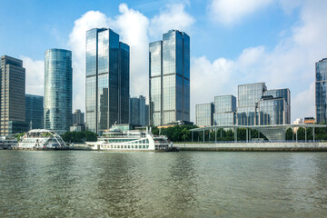 Fototapeta premium Modern high-rise buildings by the river with boats