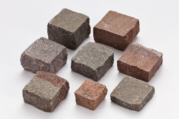 Nine square porphyry cubes in red, gray and purple—natural stone mix for classic outdoor paving.