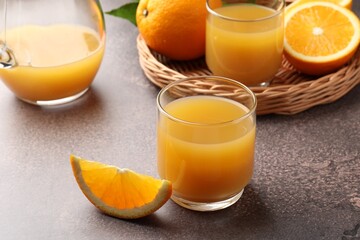 Fresh orange juice and fruits on grey table, closeup