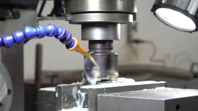CNC milling machine precision-cutting metal with coolant spray. Industrial manufacturing, machining process, metalworking, factory automation, engineering.