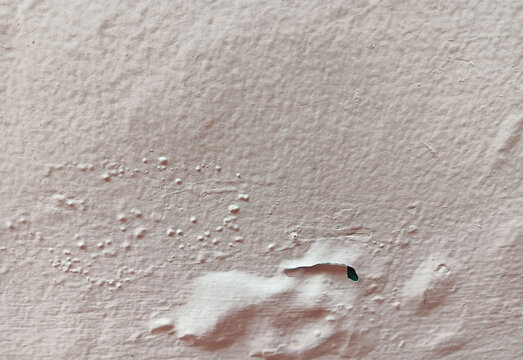 Close up of abstract texture bubbling, blistering and flaking  beige paint in a wall surface.