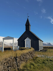 A front-facing view of Iceland&rsquo;s iconic black church, standing in stark contrast against the open Nordic landscape and expansive sky.