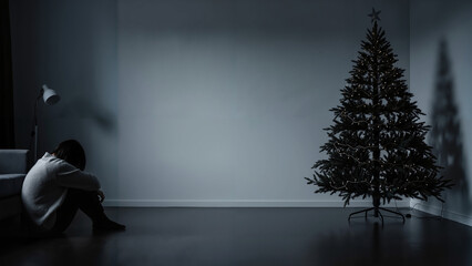 Man sitting alone by Christmas tree in dark room with shadows  