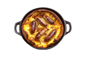 top view of traditional English toad in the hole with sausages and cheese, in a cast iron pan, isolated on a white background