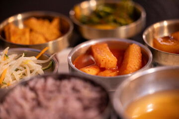 Korean food banchan side dishes on a table with artificial light at night.
