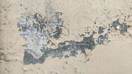 weathered beige wall with exposed concrete and erosion