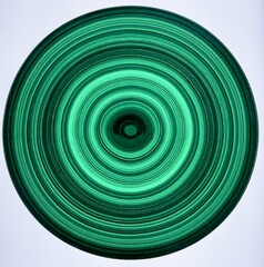 A polished malachite slice with concentric banding in green hues, isolated on pure white background.