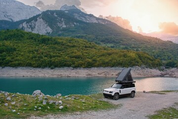 Off road car with roof tent in the wild campground. Piva Lake, Montenegro
