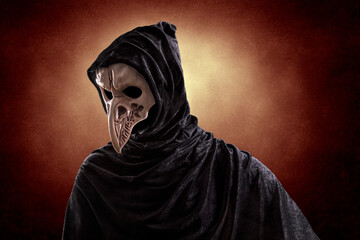 Creepy figure with animal bird skull over dark misty background