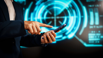 A business professional woman in a dark blue suit uses a smartphone in front of glowing digital dashboards, highlighting data analytics, technology integration, modern in futuristic workspace.